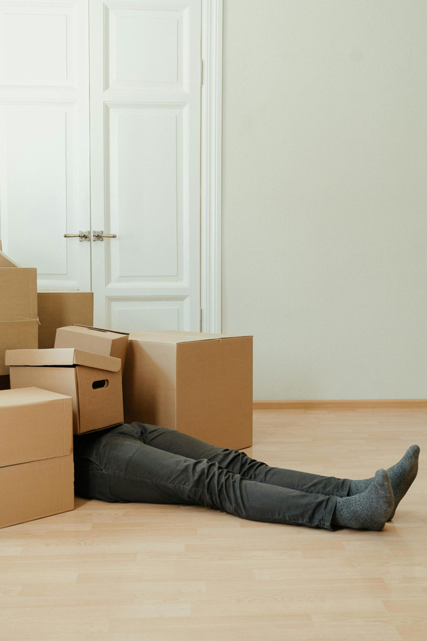 Person zwischen Umzugskartons – Symbolbild für Büroumzug und Büroverlagerung