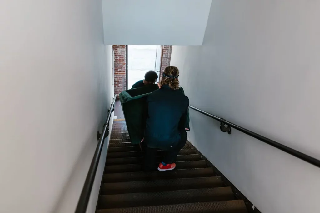 Erfahrenes Räumungsteam trägt Möbel durch enges Treppenhaus bei Haushaltsauflösung in Hamburg